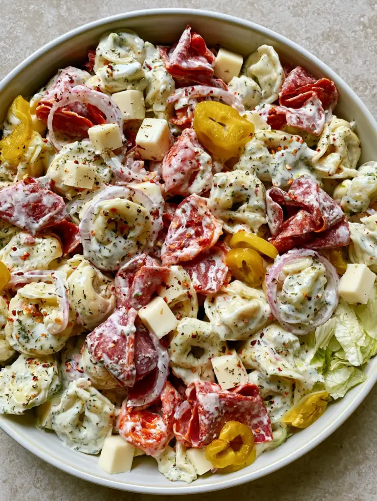 Italian Grinder Tortellini Salad: The Ultimate Creamy Pasta Salad 1 Close-up of Italian Grinder Tortellini Salad showing the texture of the creamy dressing, oregano specks, and red onion rings.