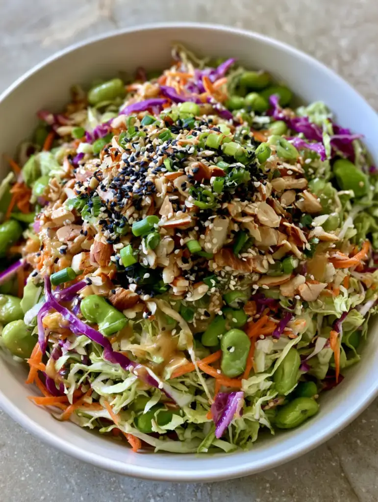 Crunchy Asian Cabbage Salad with Sesame Ginger Vinaigrette 1 Overhead view of the Crunchy Asian Cabbage Salad topped with dual sesame seeds and sliced toasted almonds.